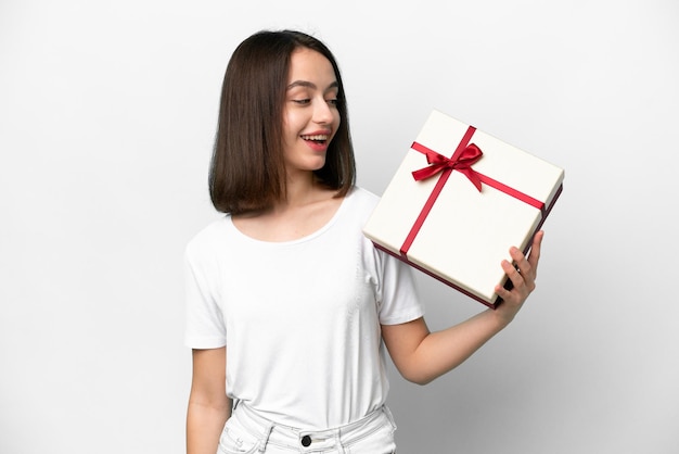 Young Ukrainian woman holding a gift isolated on white background with happy expression