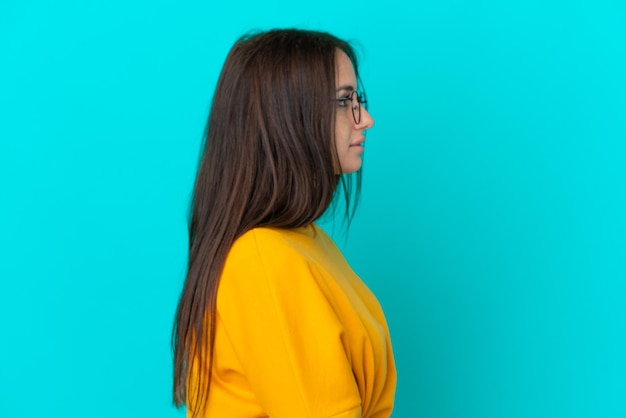 Young Ukrainian woman isolated on blue background With glasses