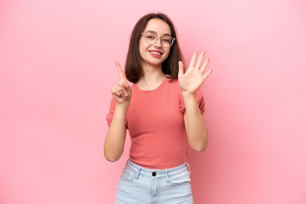 Young Ukrainian woman isolated on pink background counting six with fingers