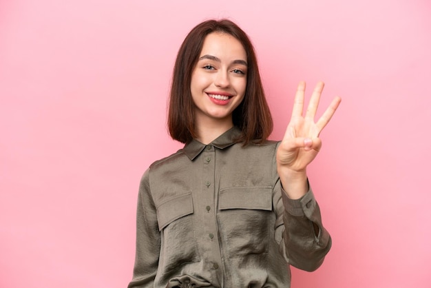 Young Ukrainian woman isolated on pink background happy and counting three with fingers