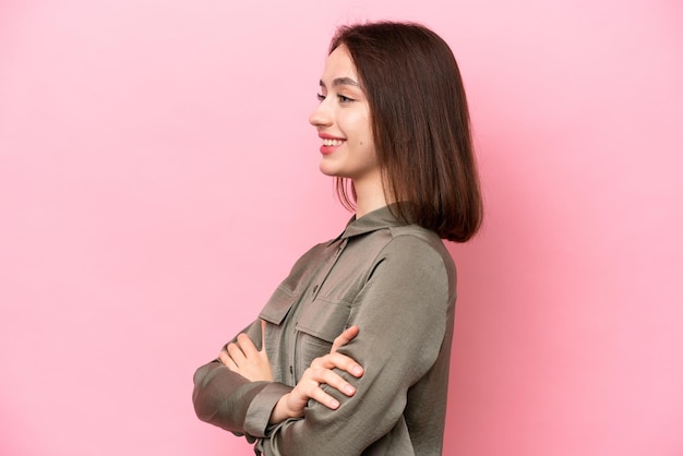 Young Ukrainian woman isolated on pink background in lateral position