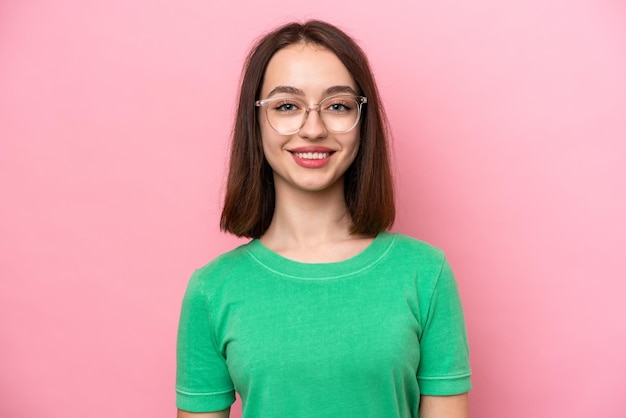 Young Ukrainian woman isolated on pink background With glasses with happy expression