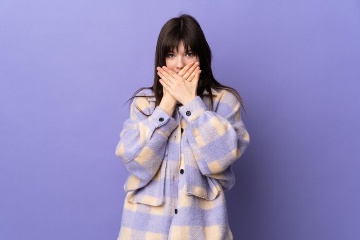Photo 紫色の背景に孤立した若いウクライナの女性が手で口を覆っている