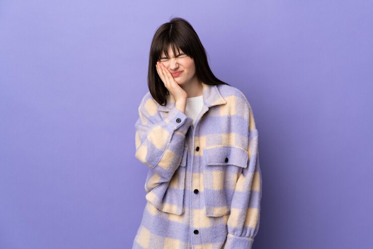 Photo 紫色の背景に孤立した歯痛の若いウクライナの女性
