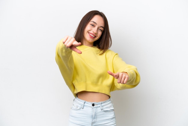 Young Ukrainian woman isolated on white background pointing front with happy expression