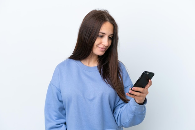 Young Ukrainian woman isolated on white background sending a message or email with the mobile