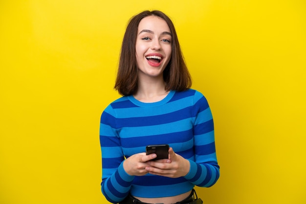 Young ukrainian woman isolated on yellow background surprised and sending a message