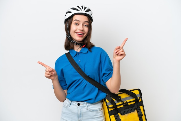 Young Ukrainian woman with thermal backpack isolated on white background pointing finger to the laterals and happy