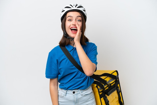 Young Ukrainian woman with thermal backpack isolated on white background shouting with mouth wide open