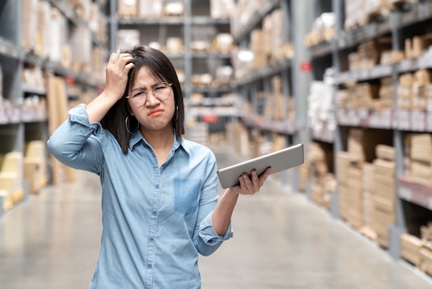 Young unhappy asian woman feeling confused in warehouse store.