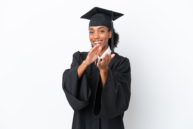 Молодая выпускница университета афроамериканка изолирована на белом фоне, аплодируя после выступления на конференции