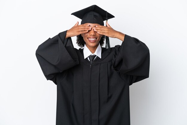 Giovane donna afroamericana laureata isolata su sfondo bianco che copre gli occhi con le mani