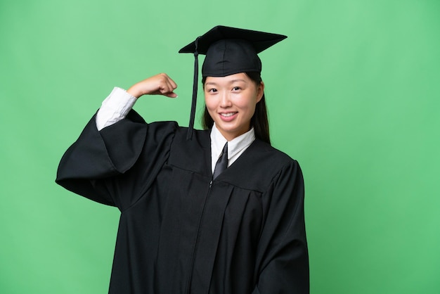 강한 몸짓을 하는 고립된 배경을 가진 젊은 대학 졸업생 아시아 여성