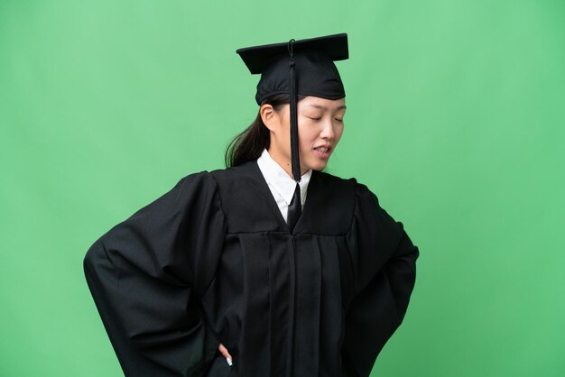 Young university graduate asian woman over isolated background suffering from backache for having made an effort