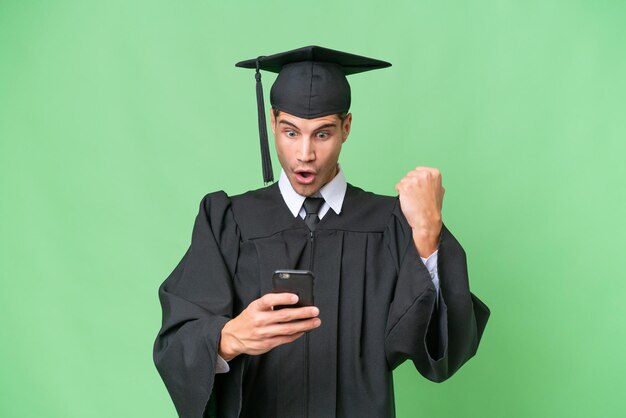 Young university graduate caucasian man over isolated background surprised and sending a message