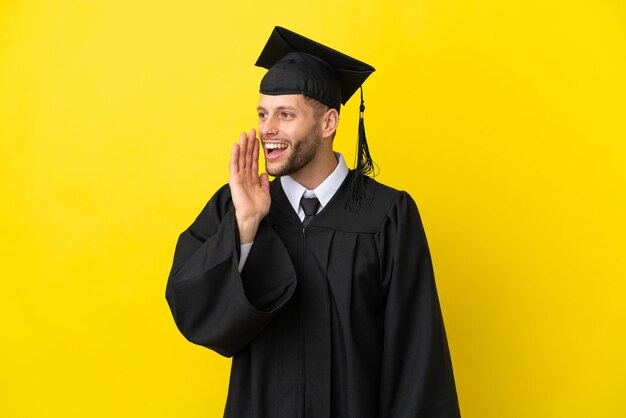 Young university graduate caucasian man isolated on yellow background shouting with mouth wide open to the lateral