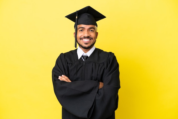 Young university graduate Colombian man isolated on yellow background keeping the arms crossed in frontal position