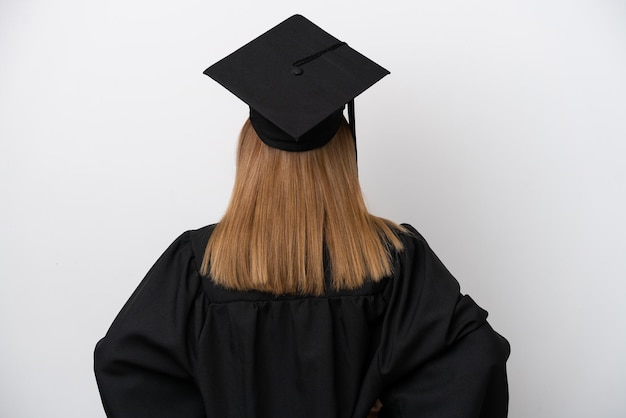Молодая выпускница университета англичанка изолирована на белом фоне в заднем положении