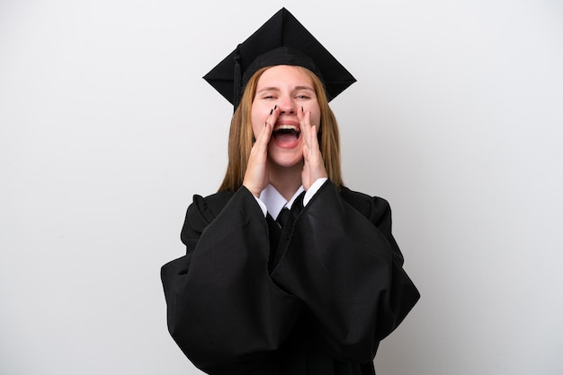 Young university graduate english woman isolated on white\
background shouting and announcing something