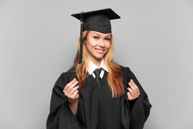 Young university graduate girl over isolated background making money gesture