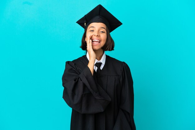 Young university graduate girl over isolated blue background shouting with mouth wide open