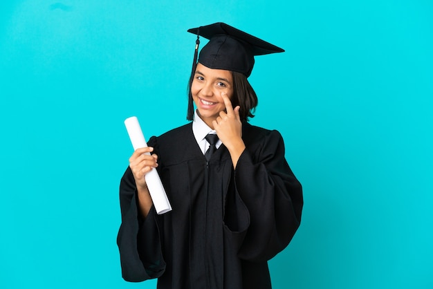 Young university graduate girl over isolated blue background showing something