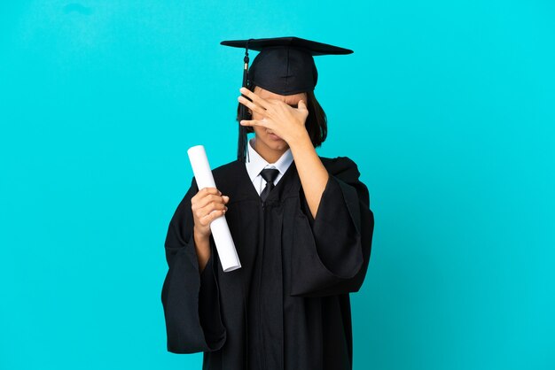 Young university graduate girl over isolated blue background with headache