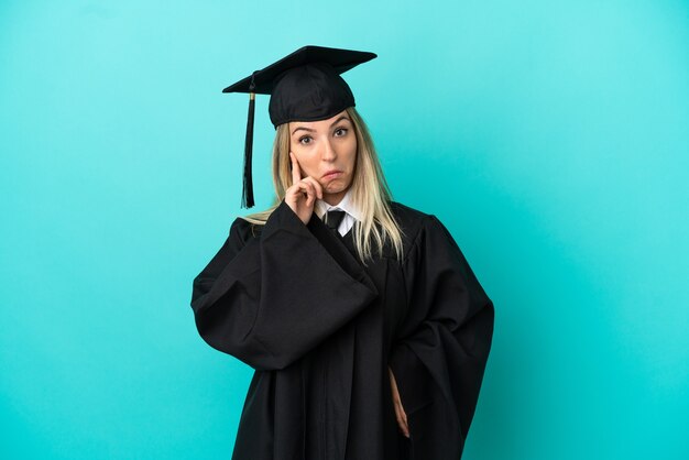 Young university graduate over isolated blue background thinking an idea