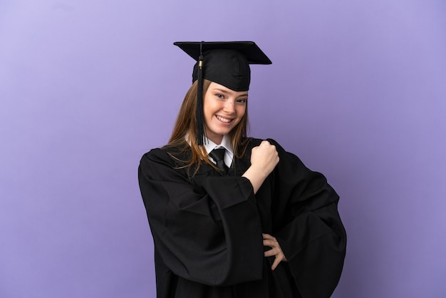 Молодой выпускник университета над изолированной фиолетовой поверхностью празднует победу