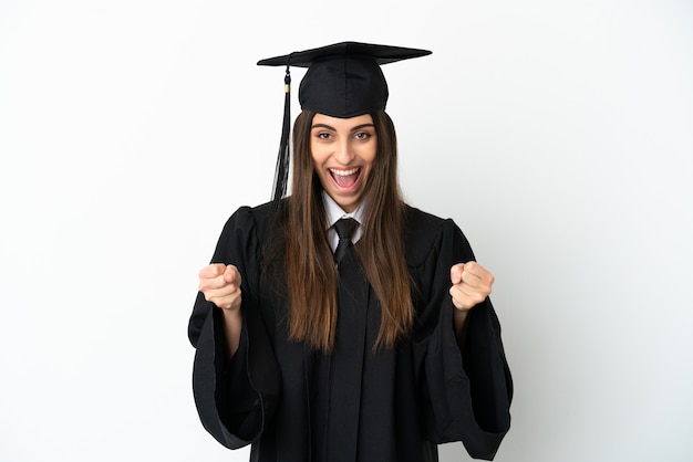 Young university graduate isolated on white background celebrating a victory in winner position