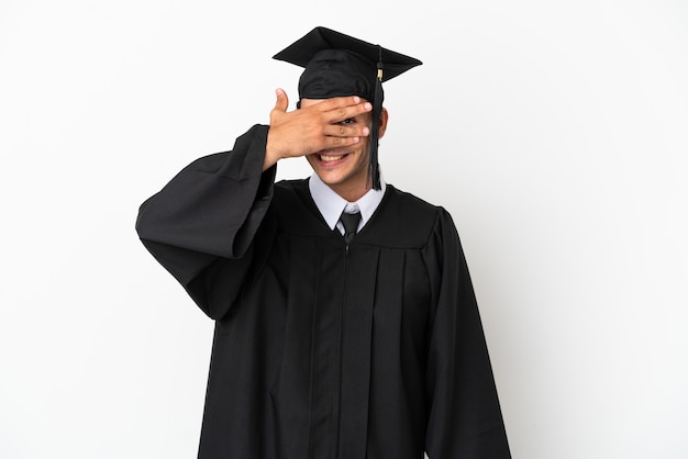 Young university graduate over isolated white background covering eyes by hands and smiling