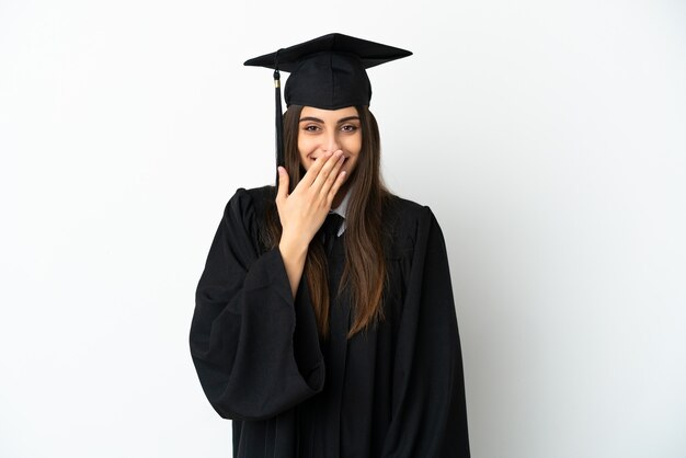 Young university graduate isolated on white background happy and smiling covering mouth with hand