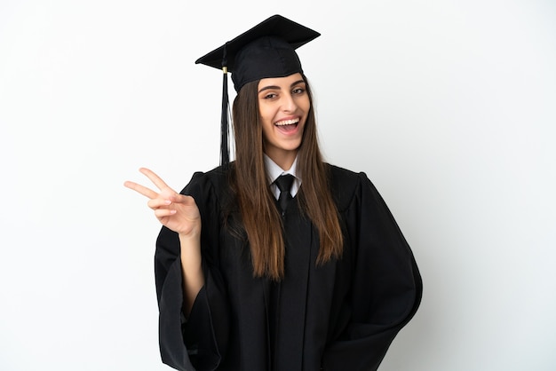 Young university graduate isolated on white background smiling and showing victory sign