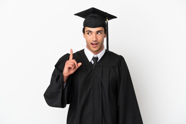 Young university graduate over isolated white background thinking an idea pointing the finger up