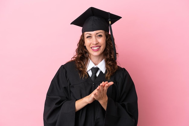 Young university graduate woman isolated on pink background applauding after presentation in a conference