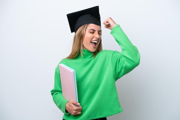 勝利を祝って白い背景で隔離の若い大学卒業生の女性