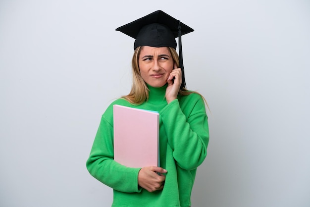 Young university graduate woman isolated on white background frustrated and covering ears