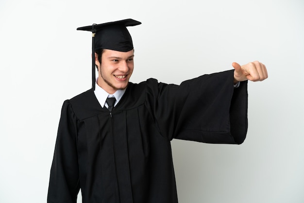 Giovane laureato russo dell'università isolato su fondo bianco che dà un gesto di pollice in alto