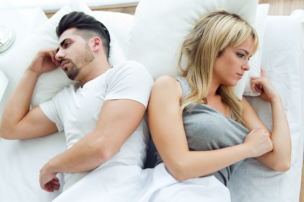 Photo young upset couple lying in bed