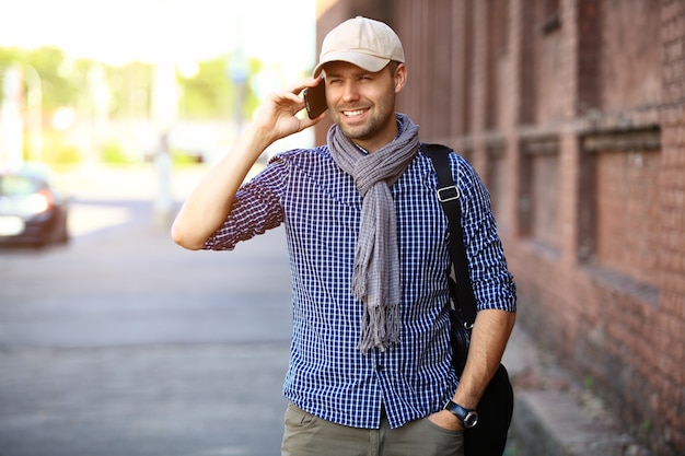 Young urban businessman professional on smartphone walking in street using app texting sms message on smartphone