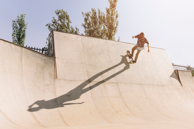 Young urban girl skating in half pipe