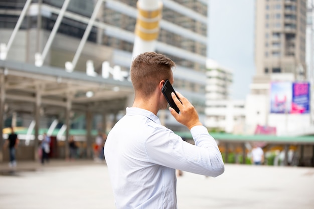 Young urban professional man using smart phone. Businessman holding mobile smart phone 