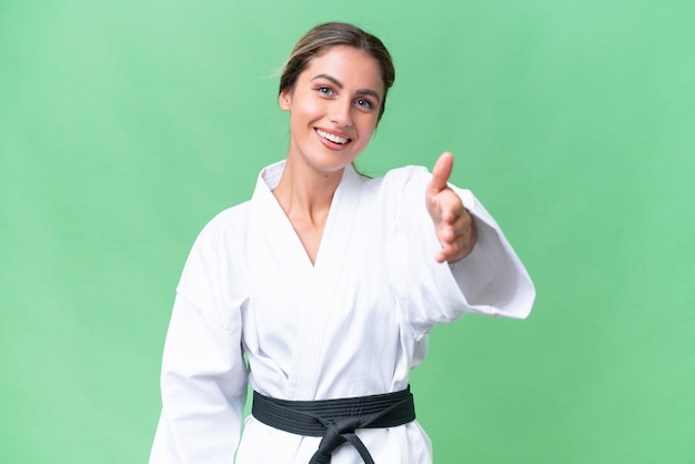 Young Uruguayan woman doing karate over isolated background shaking hands for closing a good deal