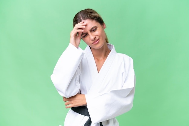 Young Uruguayan woman doing karate over isolated background with headache