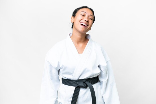 Young Uruguayan woman doing karate over isolated white background laughing