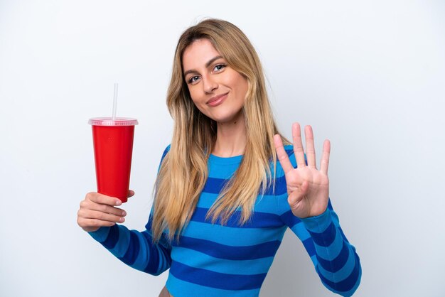 Young Uruguayan woman drinking soda isolated on white background happy and counting four with fingers