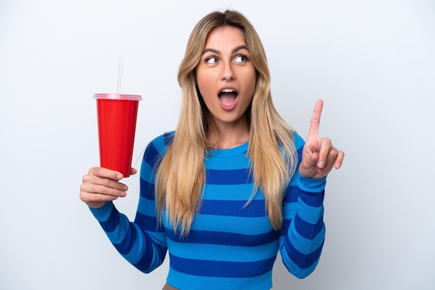 Foto giovane donna uruguaiana che beve soda isolata su sfondo bianco pensando a un'idea che punta il dito verso l'alto