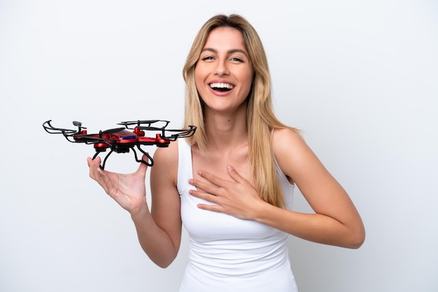 Young Uruguayan woman holding a drone isolated on white background smiling a lot