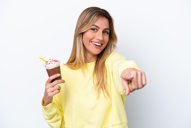 Young Uruguayan woman holding Frappuccino isolated on white background pointing front with happy expression