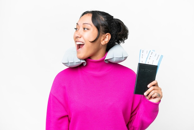 외진 흰색 배경 위에 여권을 들고 옆으로 웃고 있는 젊은 우루과이 여성